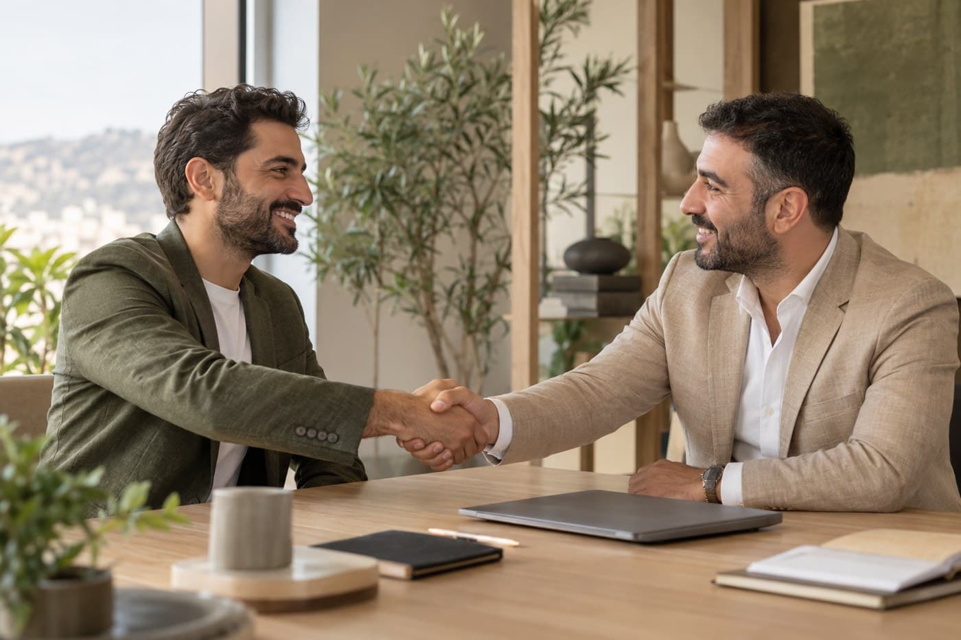 Two business professionals shaking hands in a contemporary meeting space