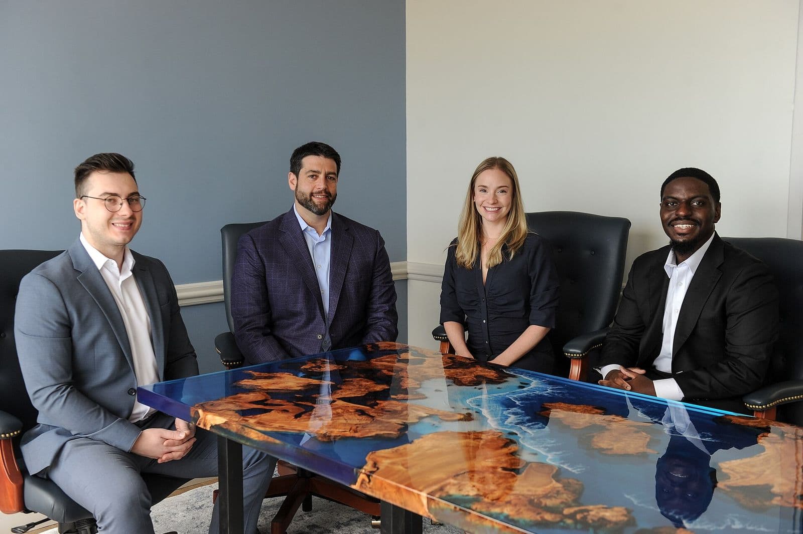 Four professionals seated around a meeting table in an advisory office
